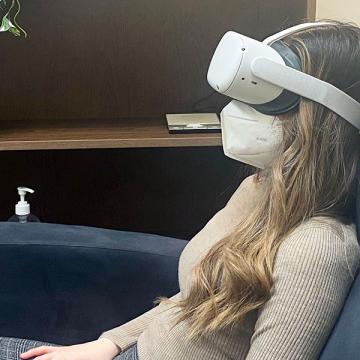 Photo of research assistant demonstrating procedure for virtual reality exposure therapy